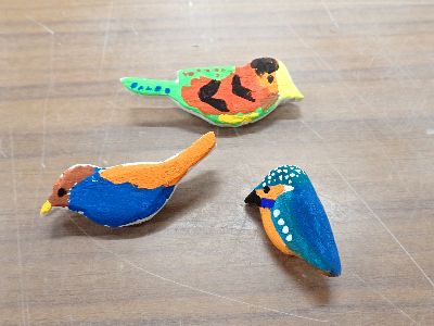 写真:カラフルな鳥のバッジ3つ