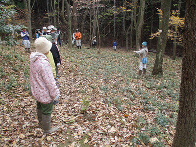 写真：柵を貼る前と後の状況説明を聞く参加者たち