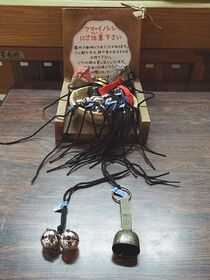 写真：受付のカゴに置かれたヒモ付きの鈴