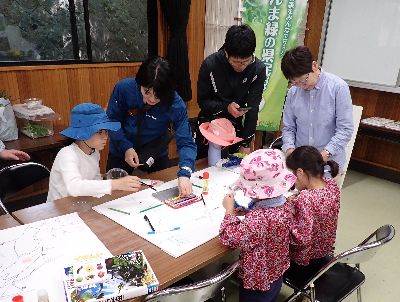 写真:絵を描いたり図鑑で調べたりしている親子