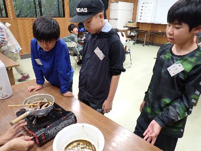 写真：布を染液に入れる子どもたち