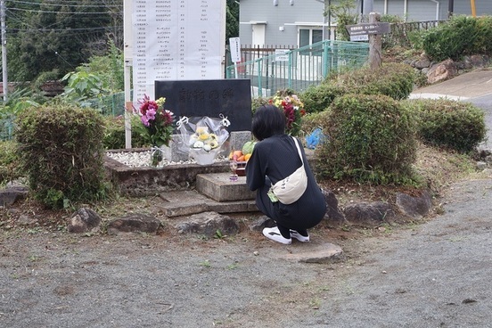 来園者が慰霊碑に手を合わせる写真